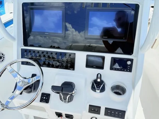 Slide: The Image of 2025 Tidewater 272 CC Adventure boat with dual 200 horsepower engines, docked outdoors. - 5