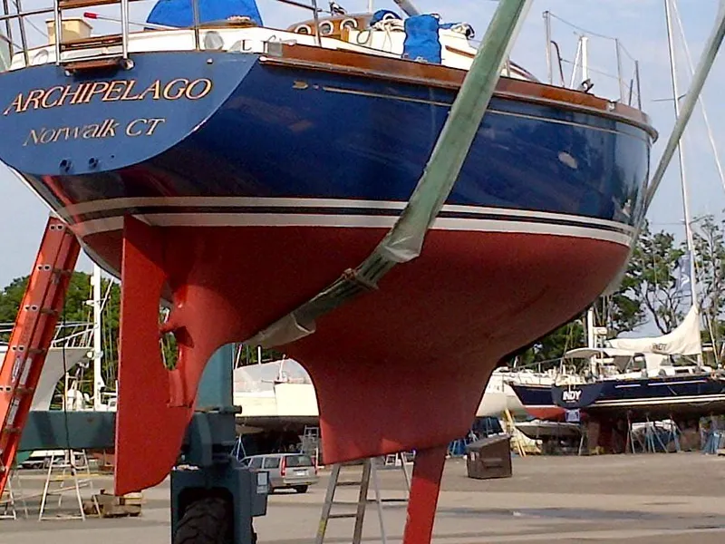 Slide: The Image of 1985 Bristol 38.8 sailboat on dry dock, blue hull, marina background. - 2