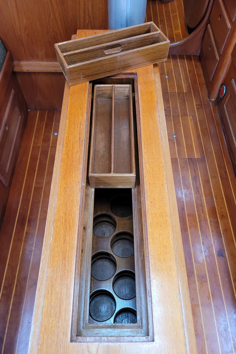 Slide: The Image of Interior of 1985 Bristol 38.8 sailboat with wooden table and green cushioned seating. - 23