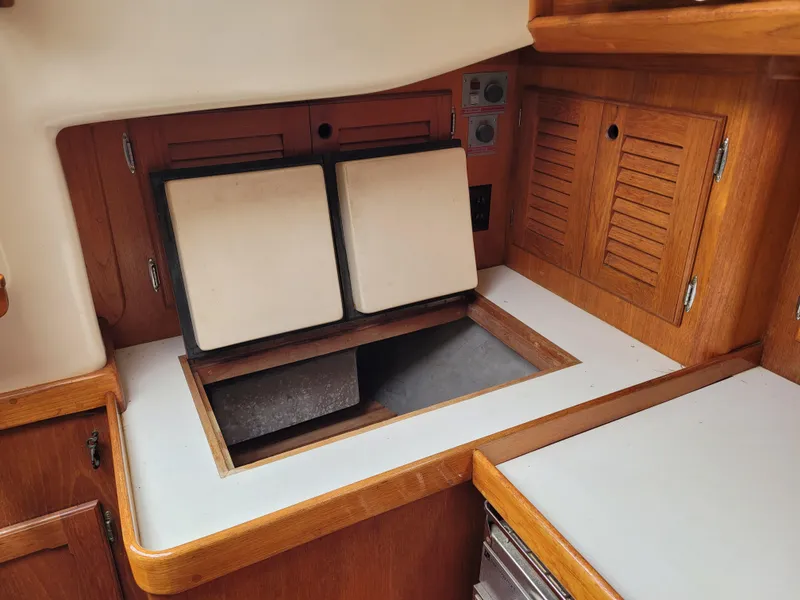 Slide: The Image of Wooden interior of 1985 Bristol 38.8 sailboat with blue cushions and shoe visible. - 26