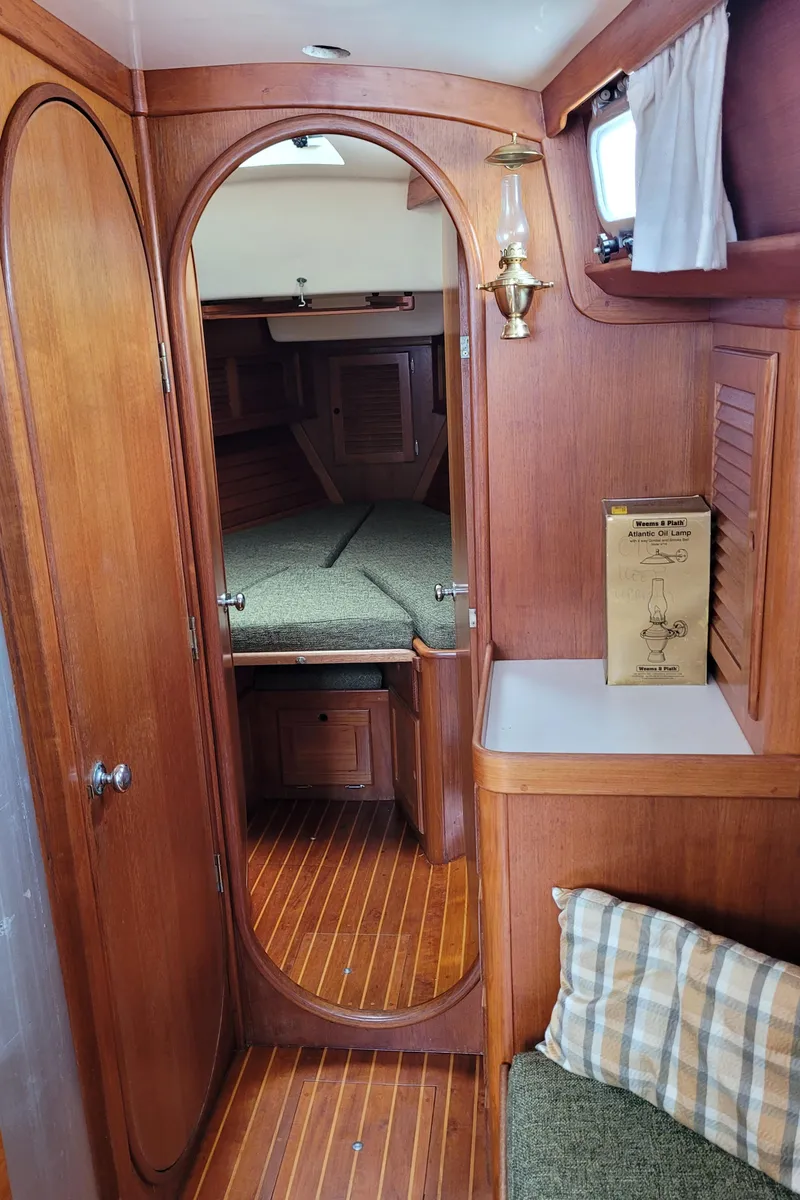 Slide: The Image of Interior of 1985 Bristol 38.8 sailboat with wooden finish and cozy sleeping area. - 33
