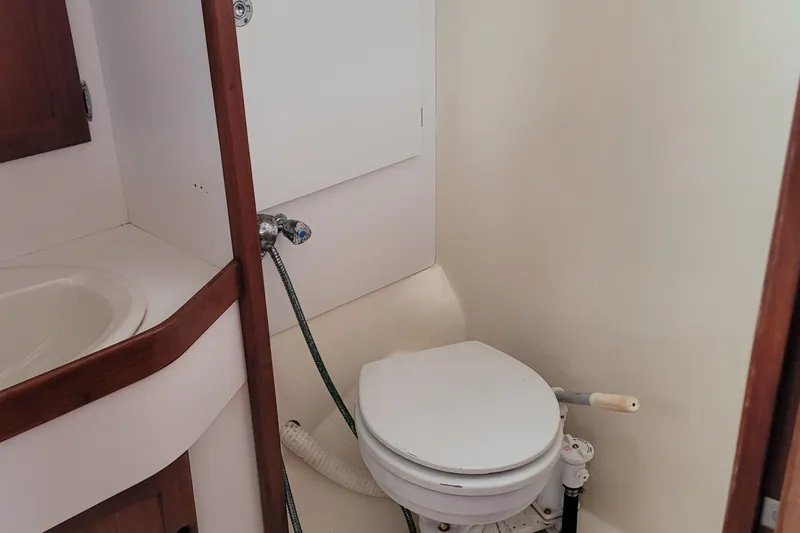 Slide: The Image of 1985 Bristol 38.8 yacht bathroom with wooden cabinets, mirror, and toilet. - 36