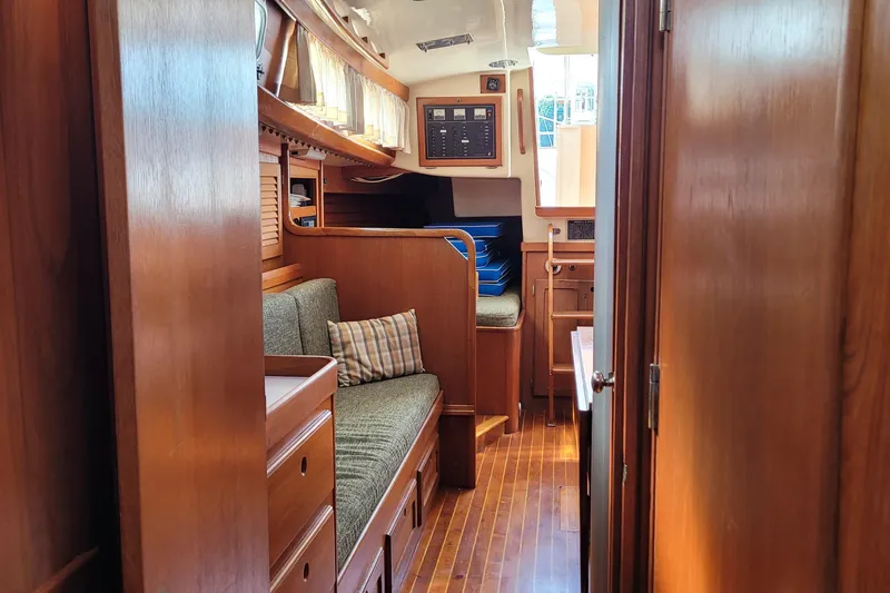 Slide: The Image of Interior cabin of 1985 Bristol 38.8 sailboat with wooden paneling and plaid pillow. - 41