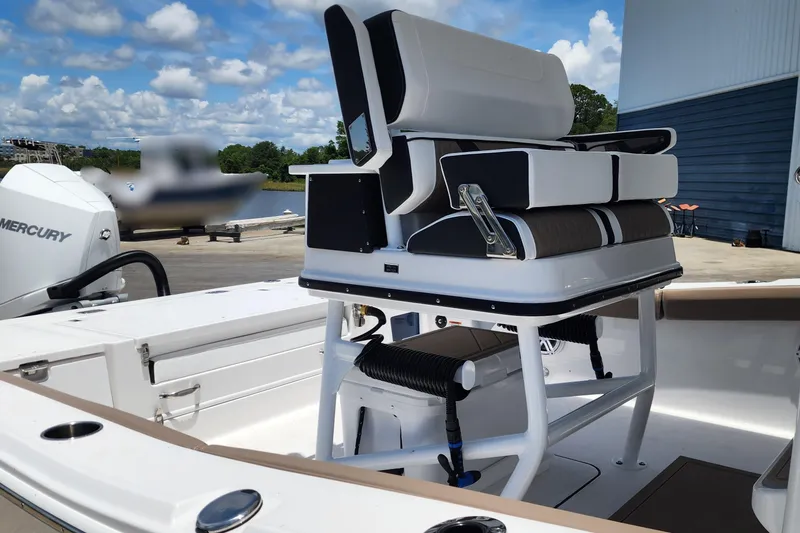 Slide: The Image of 2026 Blackfin 242HB boat interior with seating and Mercury engine, dockside view. - 10