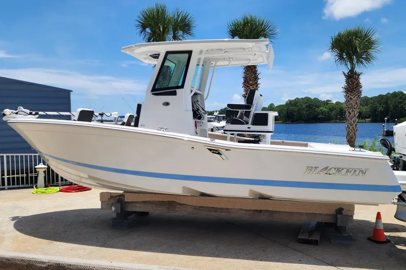 Slide: The Image of 2026 Blackfin 242HB boat on display near a waterfront, under a clear blue sky. - 3