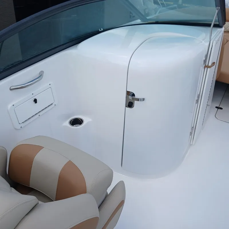 Slide: The Image of 2025 NauticStar 243 DC Deck boat interior with tan and white seating. - 6