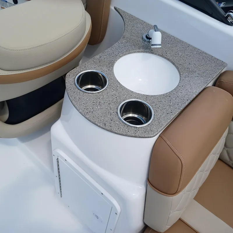 Slide: The Image of 2025 NauticStar 243 DC Deck boat interior with sink and cup holders. - 7