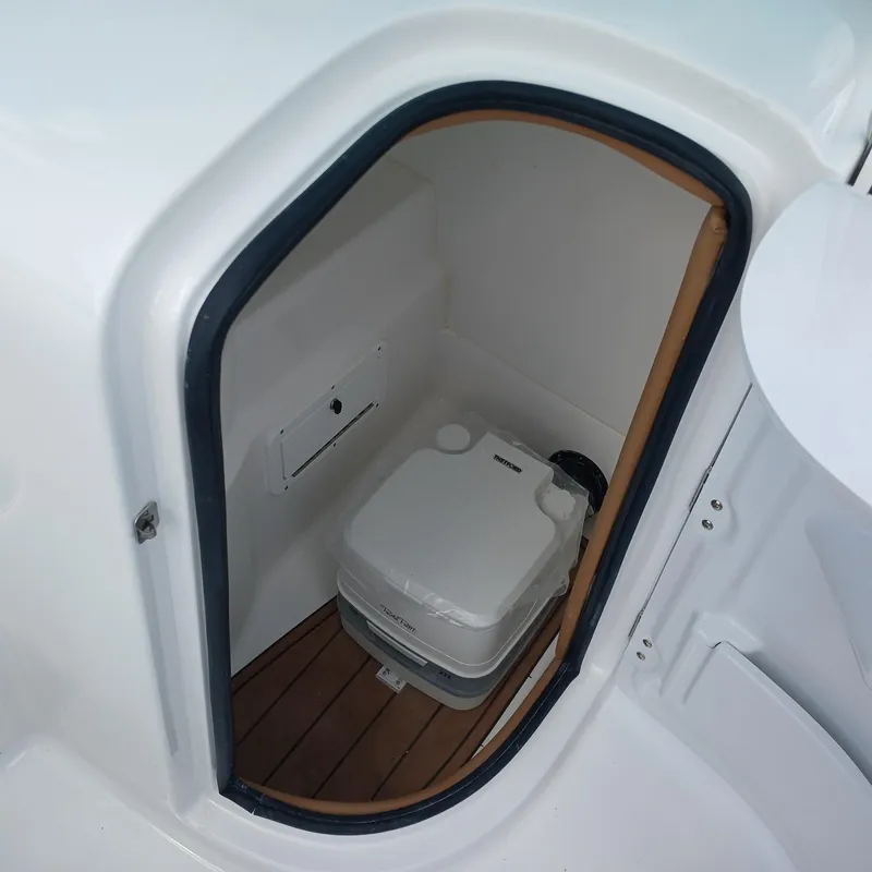 Slide: The Image of 2025 NauticStar 243 DC Deck boat interior with compact marine toilet. - 8