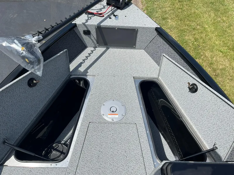 Slide: The Image of 2026 Lund 1675 Adventure SS boat interior with storage compartments and control panel. - 14