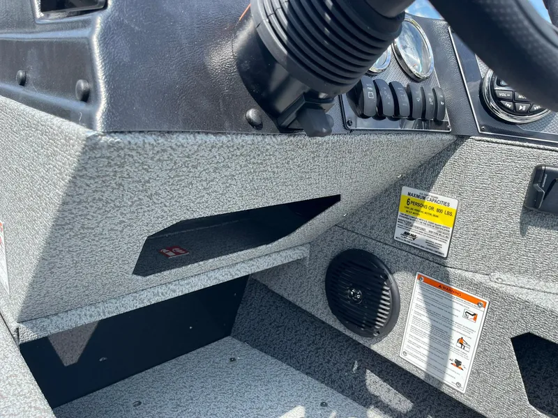 Slide: The Image of Control panel of 2026 Lund 1675 Adventure SS boat, featuring gauges and capacity warning labels. - 18