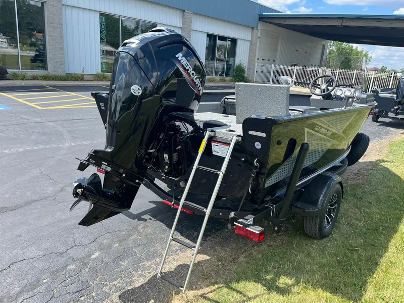 Slide: The Image of 2026 Lund 1675 Adventure SS boat with Mercury outboard motor, parked outdoors. - 2