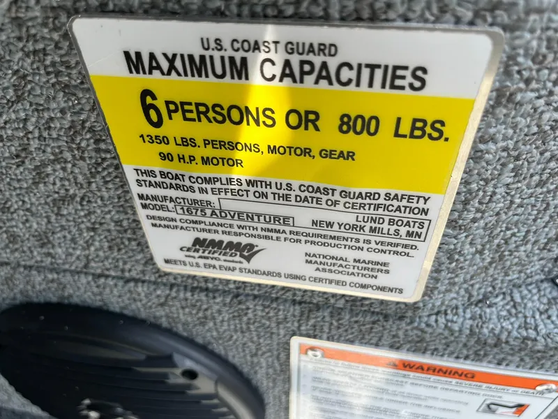 Slide: The Image of U.S. Coast Guard capacity label for 2026 Lund 1675 Adventure SS boat, 6 persons or 800 lbs. - 24