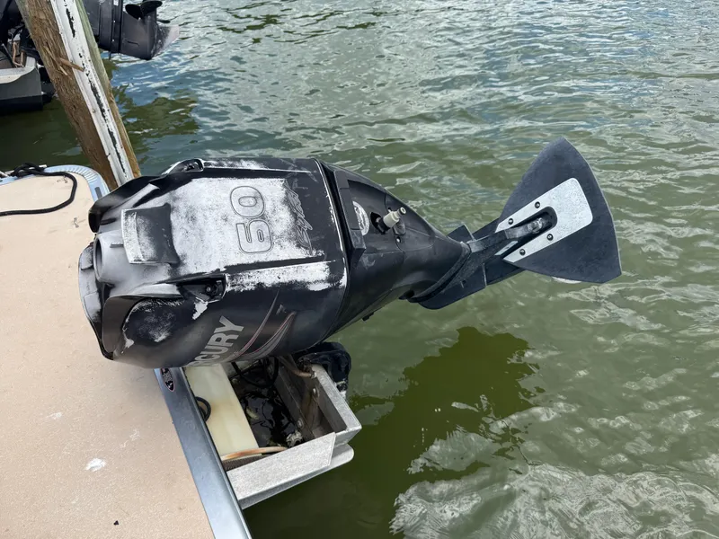 Slide: The Image of Outboard motor on a Harris FloteBote Cruiser 200, 2014 model, docked by the water. - 12