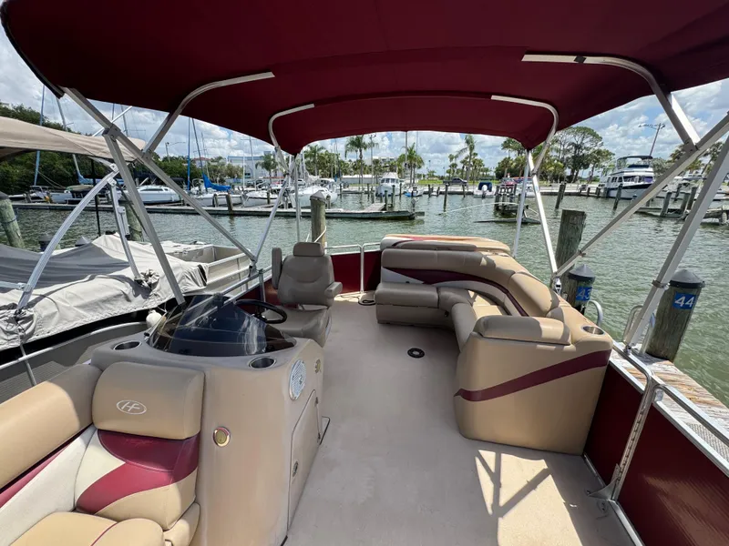 Slide: The Image of 2014 Harris FloteBote Cruiser 200 pontoon boat with red canopy at marina dock. - 2