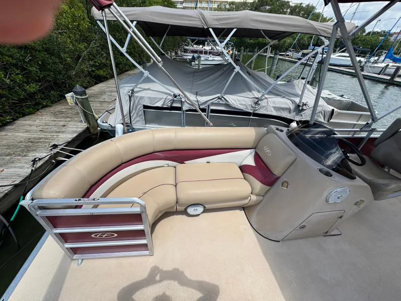 Slide: The Image of 2014 Harris FloteBote Cruiser 200 pontoon boat interior with seating and helm at dock. - 4