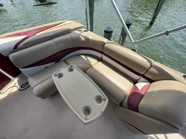 Slide: The Image of 2014 Harris FloteBote Cruiser 200 boat interior with beige and maroon seating, table, and cup holders. - 7