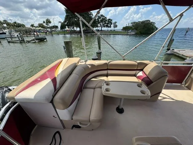 Slide: The Image of 2014 Harris FloteBote Cruiser 200 pontoon boat with seating and table, docked by a scenic lake. - 8