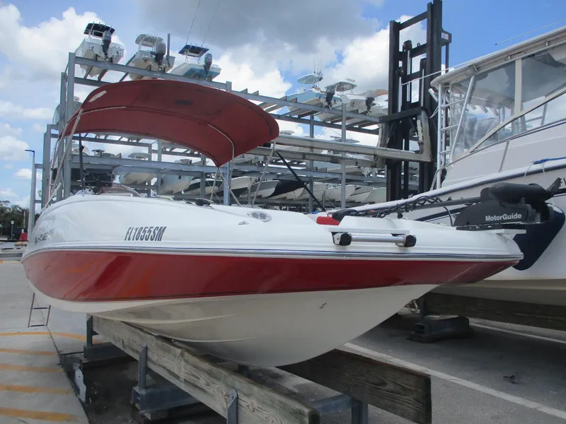 The Image of 2019 Tahoe 2150 boat with red and white design on a storage rack. - 0