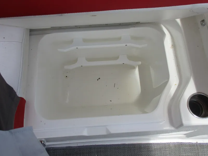 Slide: The Image of Storage compartment in 2019 Tahoe 2150 boat, featuring white interior and cup holder. - 13