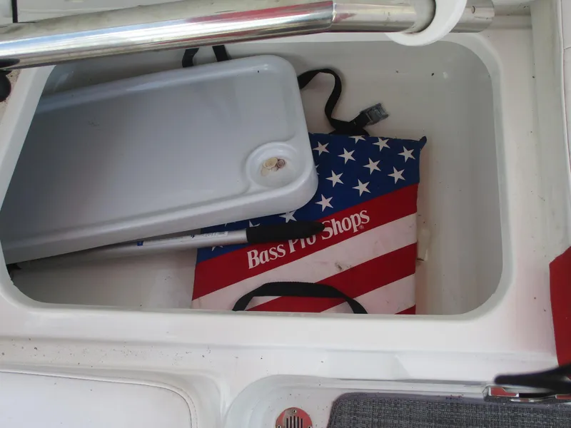Slide: The Image of Storage compartment in 2019 Tahoe 2150 boat with Bass Pro Shops bag and cutting board. - 14