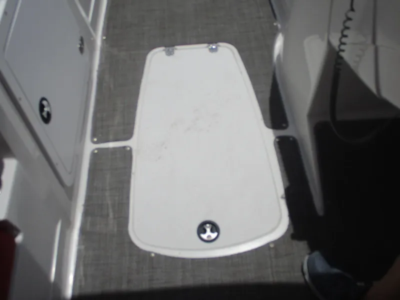Slide: The Image of 2019 Tahoe 2150 boat interior with storage compartment and gray flooring. - 28