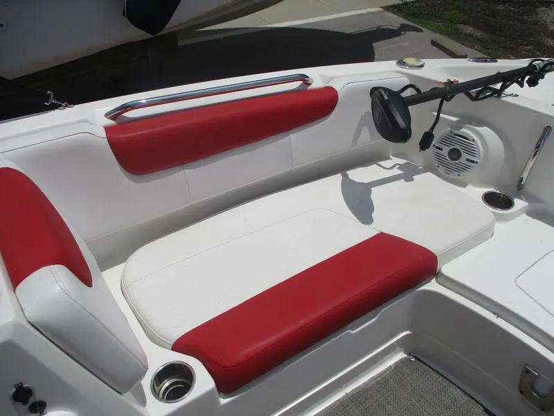 Slide: The Image of 2019 Tahoe 2150 boat interior with red and white seating, cup holders, and speaker. - 4