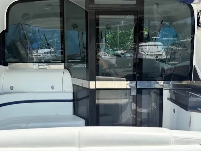 Slide: The Image of 2017 Formula 45 Yacht interior with sleek seating and glass doors, docked at a marina. - 12