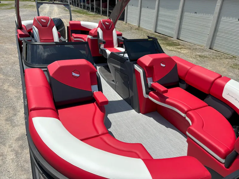 Slide: The Image of 2026 South Bay 523 RS-DC pontoon boat with red and white seating, docked outdoors. - 4
