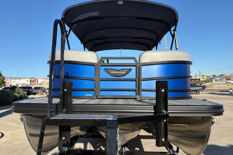 Slide: The Image of 2026 Bennington 26 MSB pontoon boat with blue exterior and canopy, parked on a trailer. - 20
