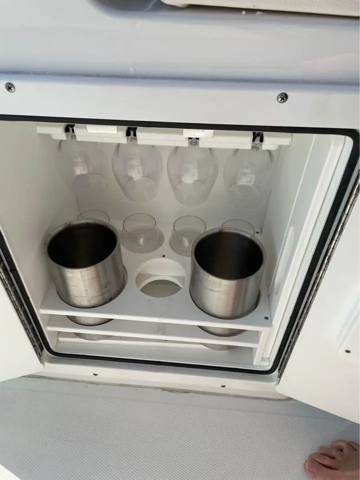 Slide: The Image of 2023 Sea Hunt Ultra 265 SE boat storage with cup holders and glasses. - 11