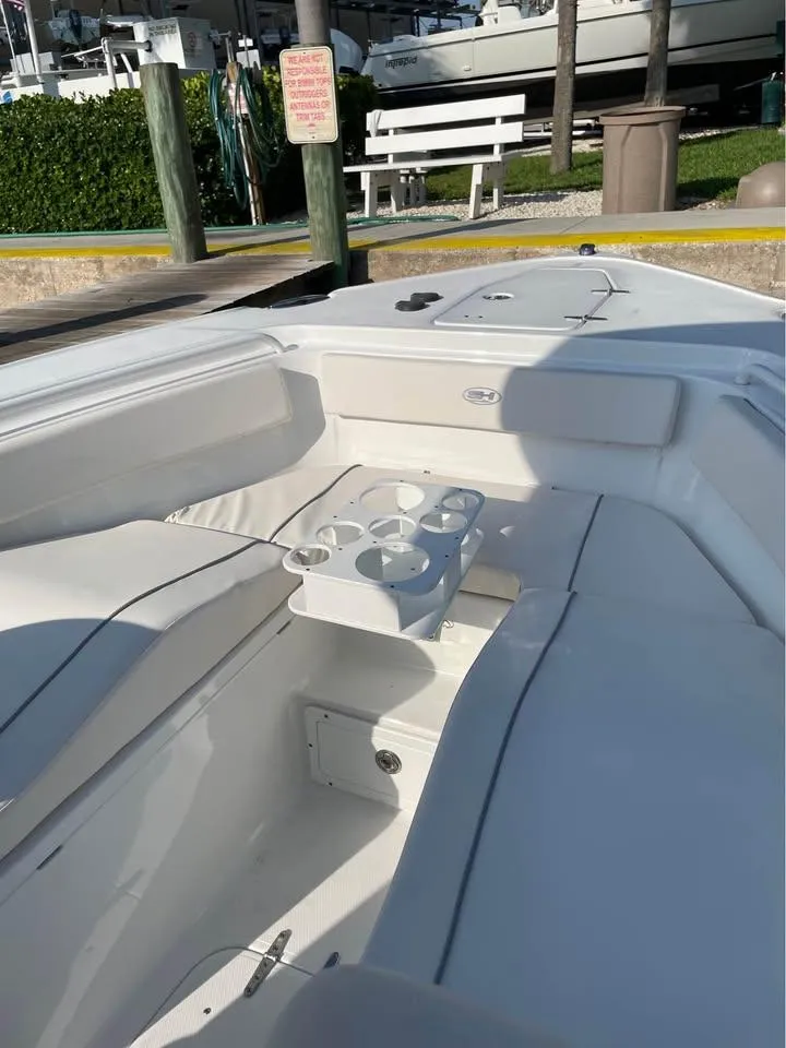 Slide: The Image of 2023 Sea Hunt Ultra 265 SE boat interior with seating and cup holders. - 13