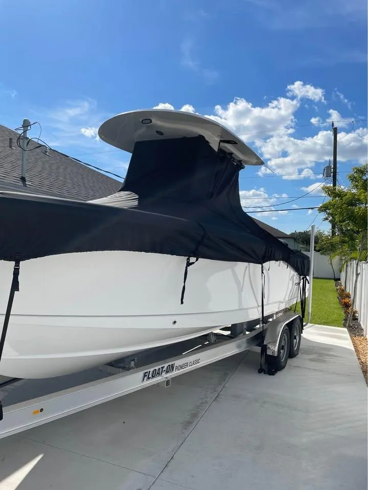 Slide: The Image of 2023 Sea Hunt Ultra 265 SE boat covered on trailer, sunny day. - 16