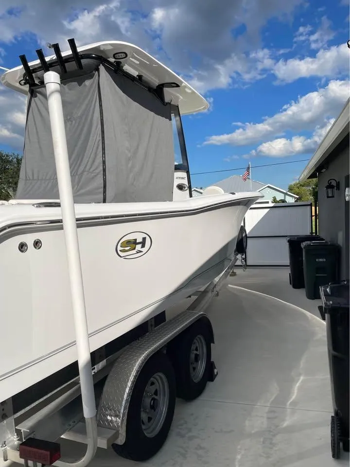 Slide: The Image of 2023 Sea Hunt Ultra 265 SE boat on trailer under blue sky. - 17