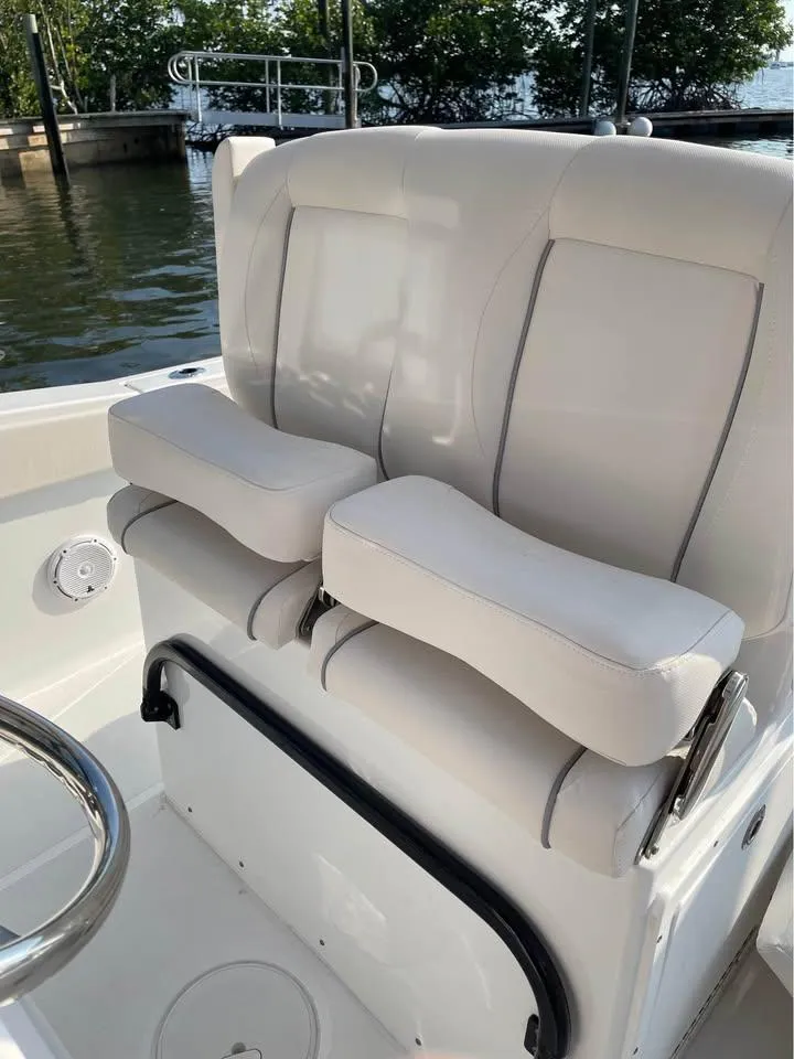 Slide: The Image of 2023 Sea Hunt Ultra 265 SE boat seats with armrests, dockside view. - 6