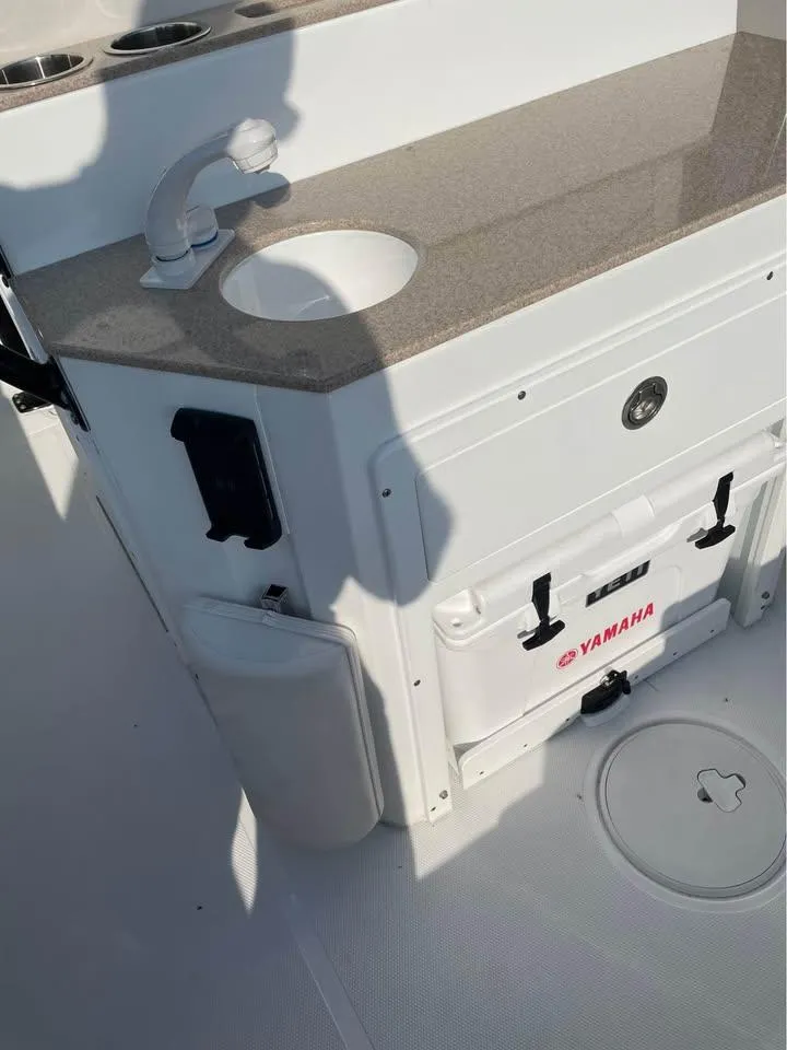 Slide: The Image of 2023 Sea Hunt Ultra 265 SE boat interior with sink and Yamaha cooler. - 7