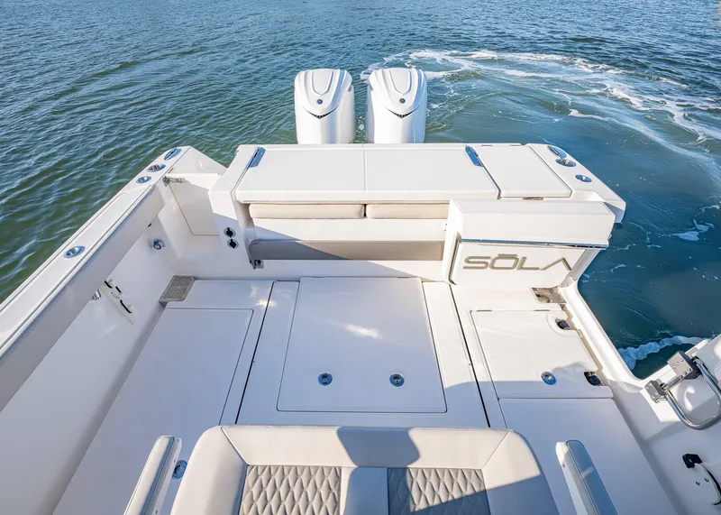 Slide: The Image of 2025 Solace 30 CS boat deck with dual engines on calm water. - 11