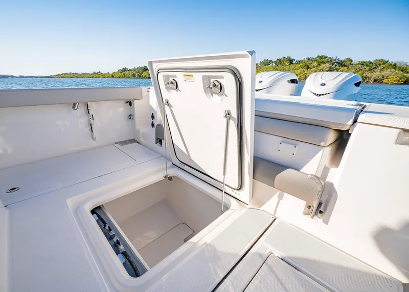 Slide: The Image of 2025 Solace 30 CS boat with open storage compartment, scenic water view. - 12