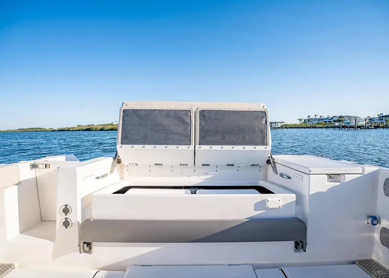 Slide: The Image of 2025 Solace 30 CS boat interior with open storage, calm water, and clear blue sky. - 18