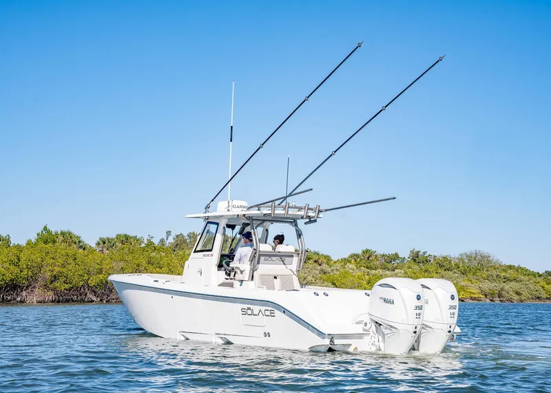 Slide: The Image of 2025 Solace 30 CS boat with dual Yamaha engines on a sunny day. - 2