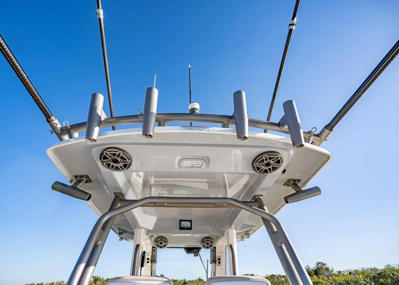 Slide: The Image of 2025 Solace 30 CS boat with fishing rod holders and speakers under clear blue sky. - 25