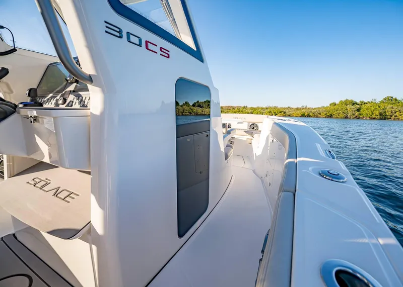 Slide: The Image of 2025 Solace 30 CS boat interior with sleek design on calm water. - 46