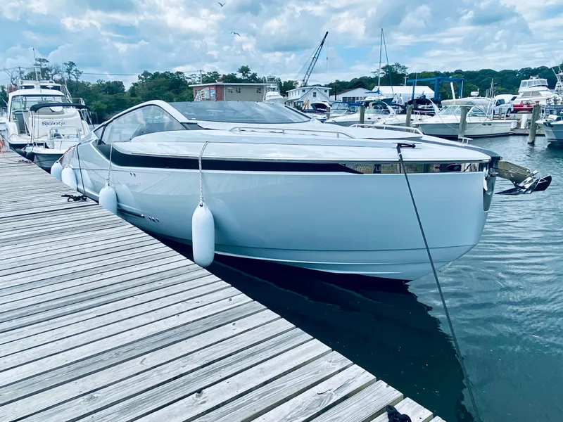 Slide: The Image of 2022 Fairline F//Line 33 yacht docked at marina, sleek design, calm water, cloudy sky. - 3