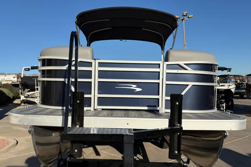 Slide: The Image of 2026 Bennington 21 SSR pontoon boat with sleek design and canopy, parked outdoors. - 4