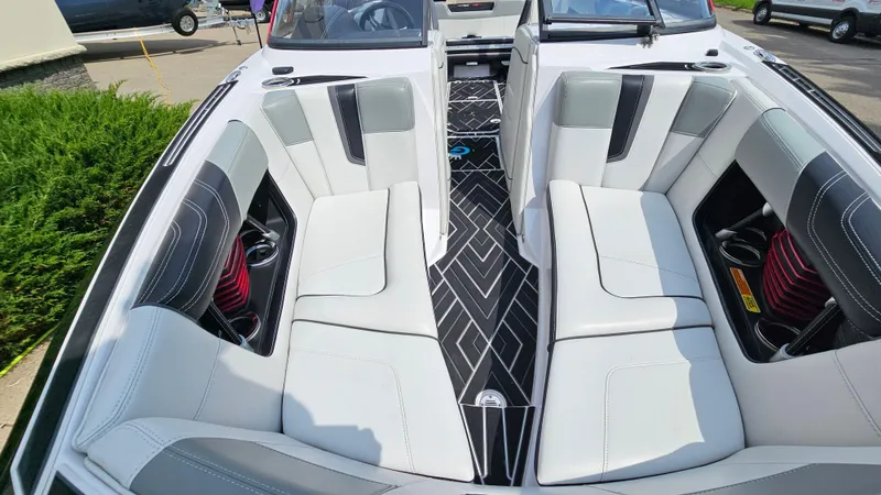 Slide: The Image of 2015 Nautique Super Air G23 boat interior with white and black seating. - 19
