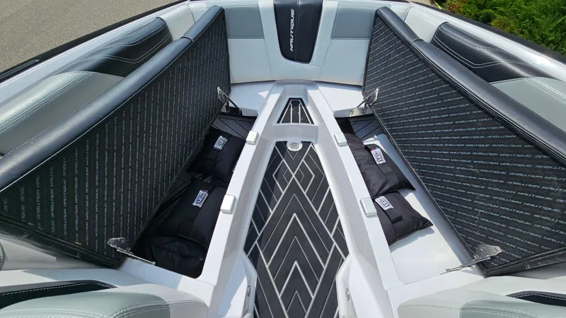 Slide: The Image of 2015 Nautique Super Air G23 boat interior with open storage compartments and cushioned seating. - 32