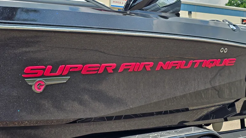 Slide: The Image of 2015 Nautique Super Air G23 boat with red logo on black hull. - 36