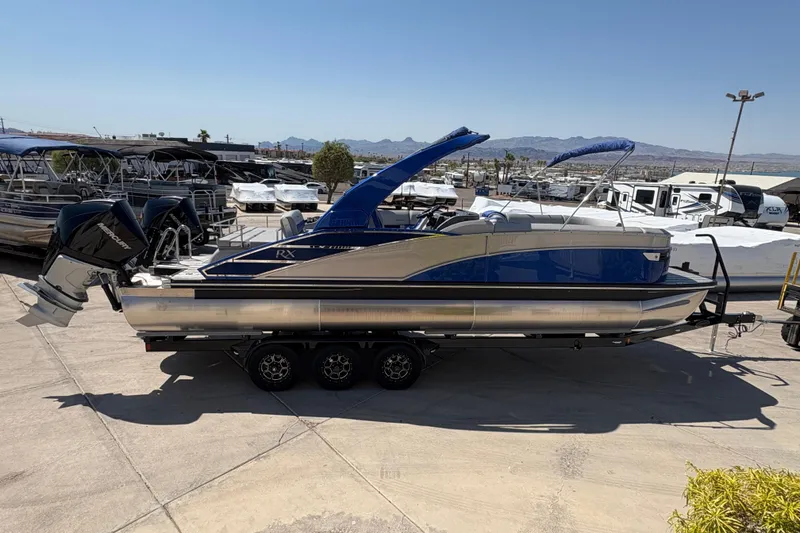 Slide: The Image of 2026 Bennington 27 RXSBAT2 pontoon boat with dual Mercury engines on a trailer. - 1