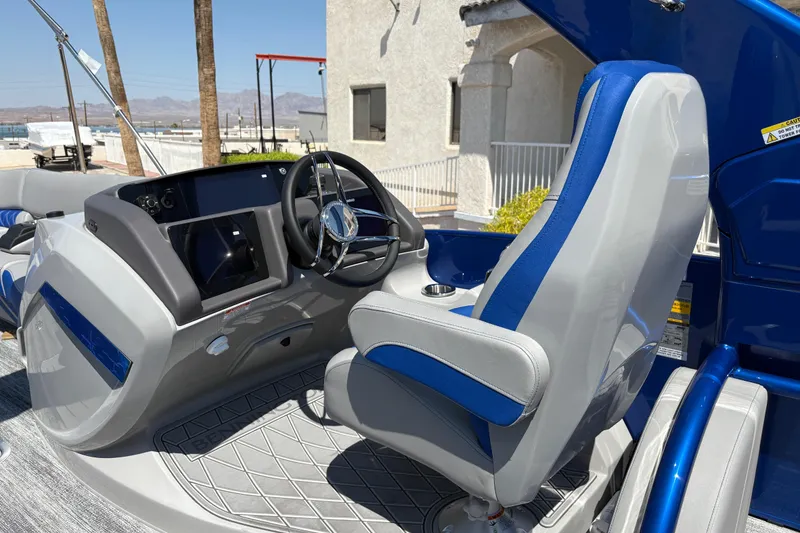 Slide: The Image of 2026 Bennington 27 RXSBAT2 boat interior with modern steering console and blue-accented captain's chair. - 10