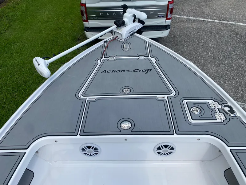Slide: The Image of 2023 Action Craft 1720 Flats Gen 3 boat with Minn Kota trolling motor, parked near a vehicle. - 32