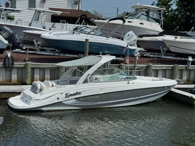The Image of 2013 Rinker 296 Captiva Bowrider docked at marina, surrounded by other boats. - 1